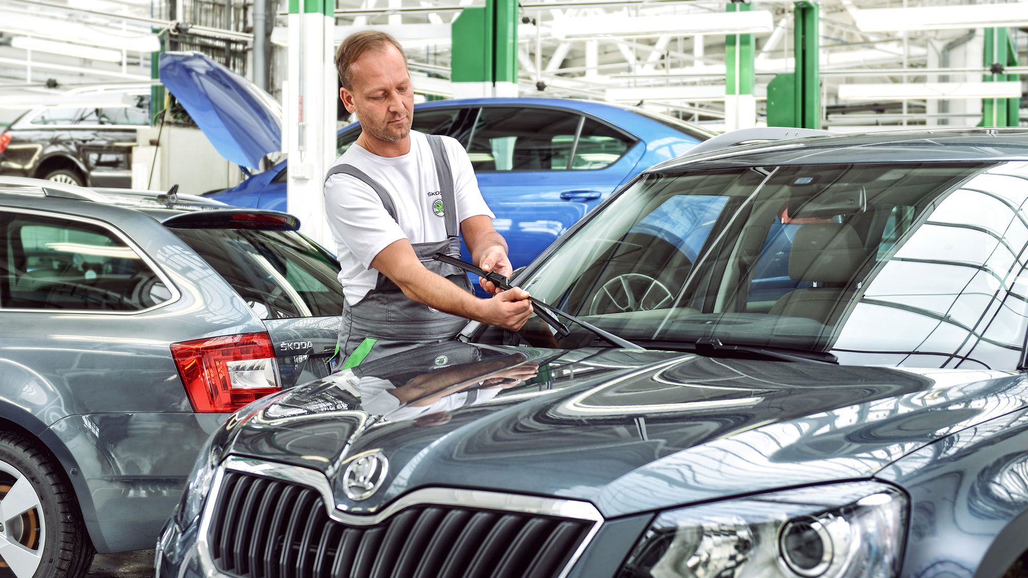 Ein Škoda Mechaniker wechselt die Wischerblätter an einem Škoda Modell