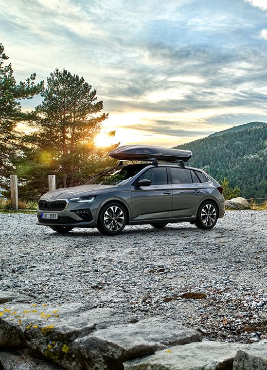 Ein Škoda Scala und ein Škoda Kamiq mit Dachbox parken in einer herbstlichen Berglandschaft.