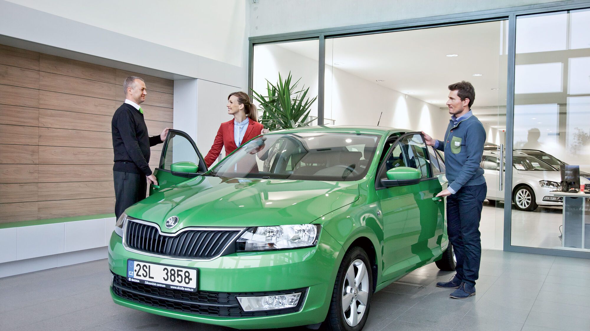 Ein Pärchen besichtigt einen grünen Škoda in einem Škoda Showroom