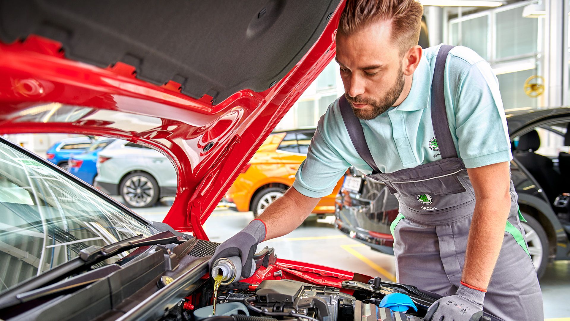 Škoda Mechaniker beim Nachfüllen von Flüssigkeiten