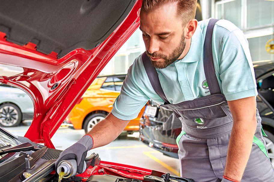 Ein Skoda Techniker beim Wechsel von Flüssigkeiten