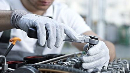 Close up shot of a technician fixing the engine of a car