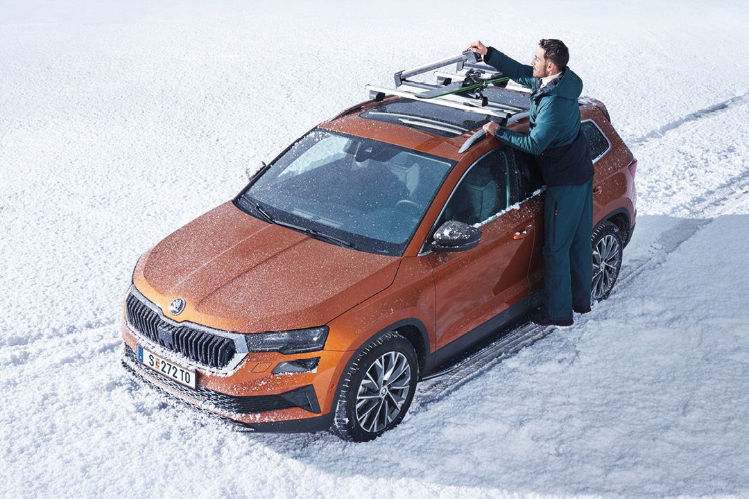 Škoda mit Dachträger auf dem von einem Mann Ski befestigt werden