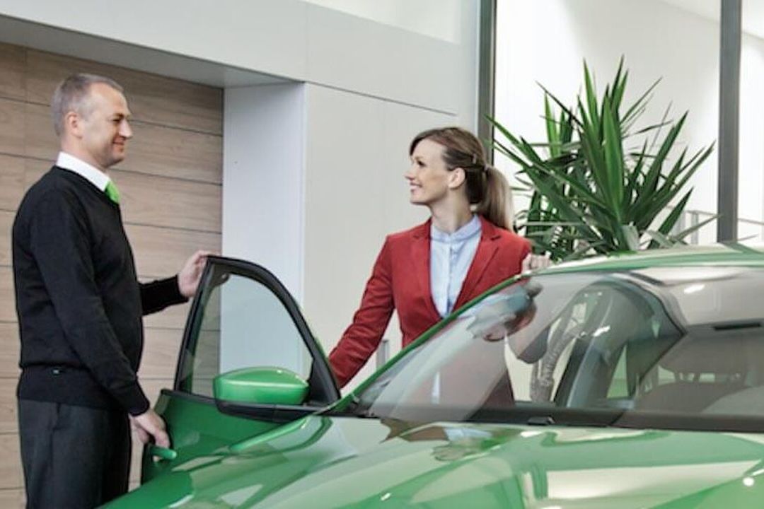 A Škoda staff opening the door for a female customer