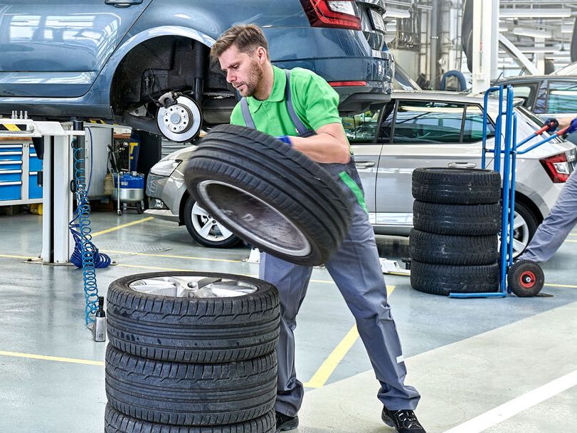 Ein Škoda Techniker stapelt Reifen