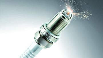 Spark plug in grey gradient background - Škoda genuine parts