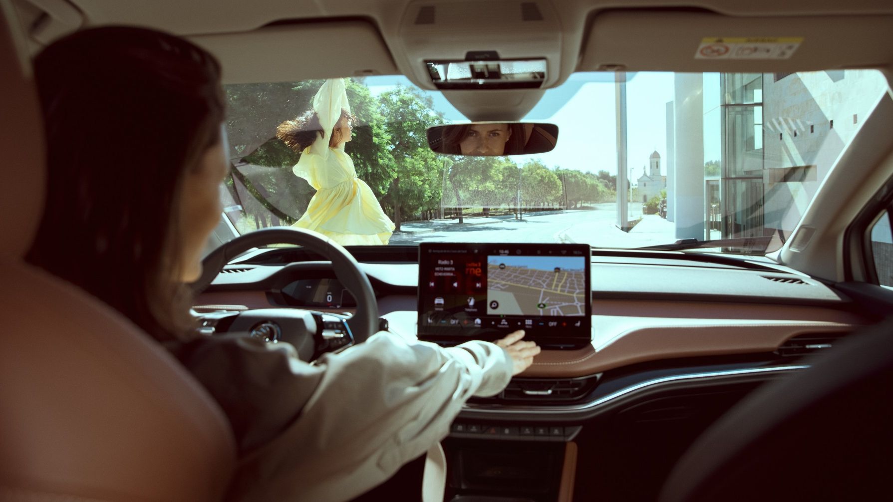 Eine Frau bedient das Navigationssystem in einem Škoda
