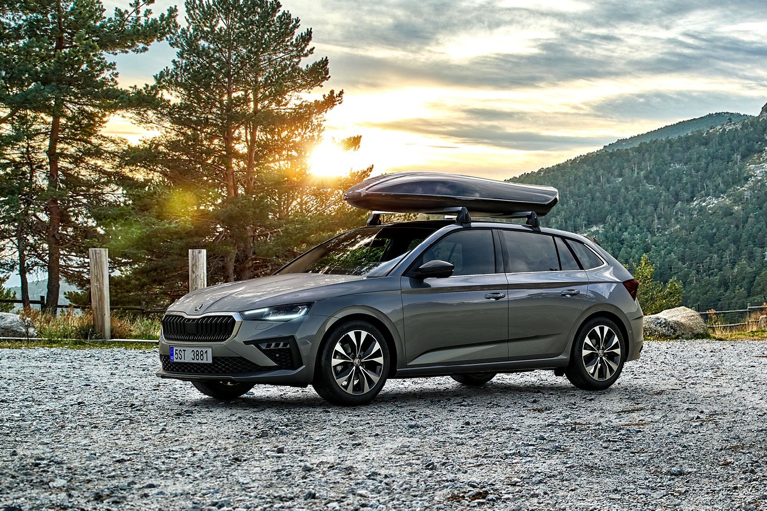 Ein Škoda Scala und ein Škoda Kamiq mit Dachbox parken in einer herbstlichen Berglandschaft.