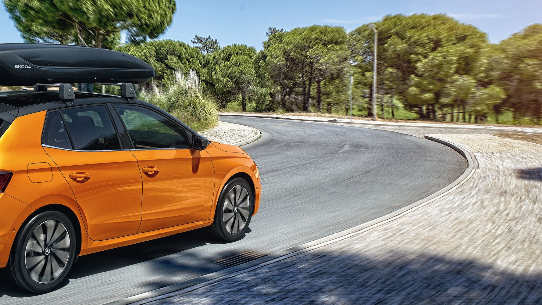 Škoda Fabia in orange mit Dachbox und Fahrrad-Heckträger