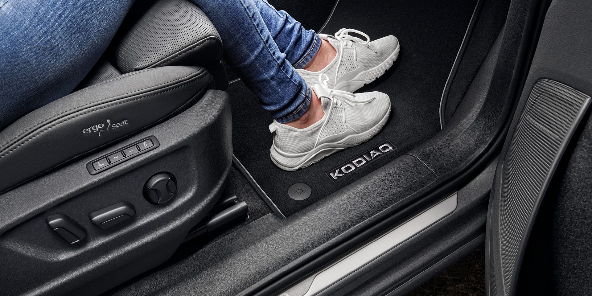 Person in einem Škoda Kodiaq mit Fokus auf die Fußmatte
