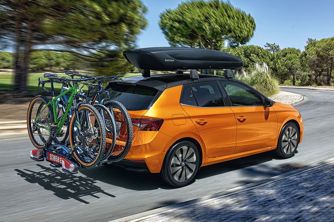 Škoda Fabia in orange mit Dachbox und Fahrrad-Heckträger