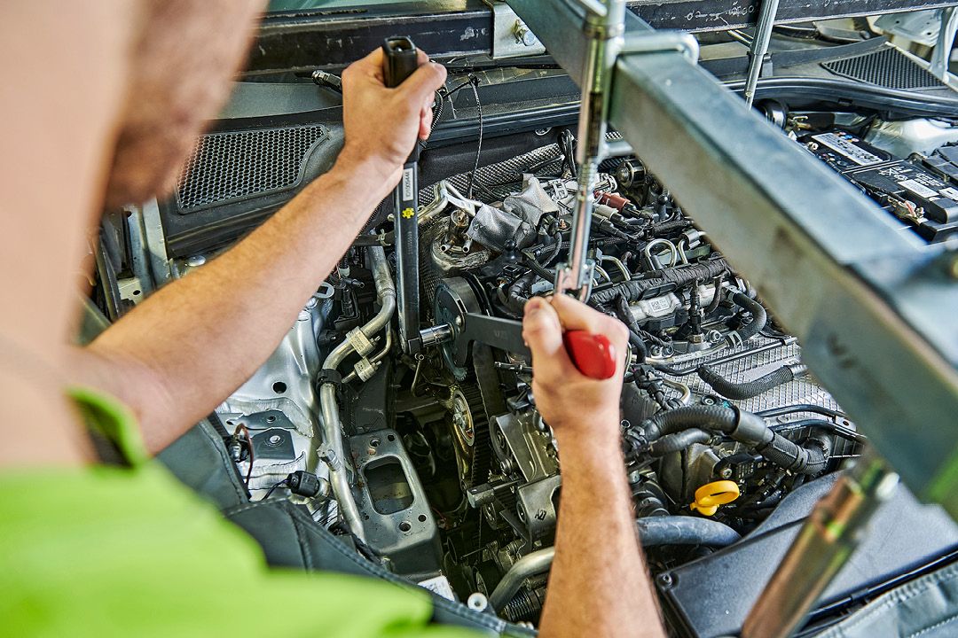 Ein Škoda Mechaniker wechselt den Zahnriemen bei einem Škoda