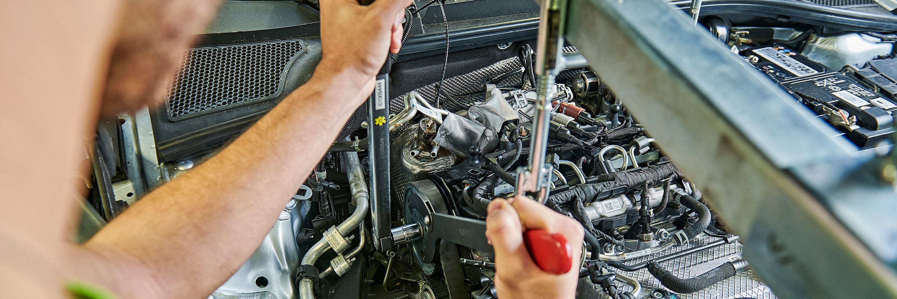 Ein Škoda Mechaniker wechselt den Zahnriemen bei einem Škoda