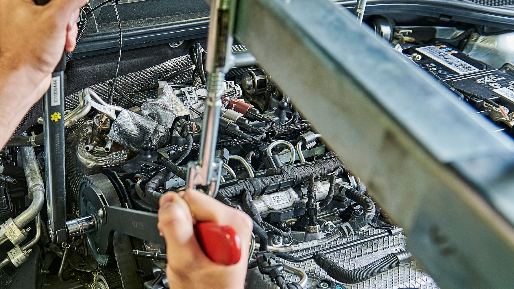Ein Škoda Mechaniker wechselt den Zahnriemen bei einem Škoda